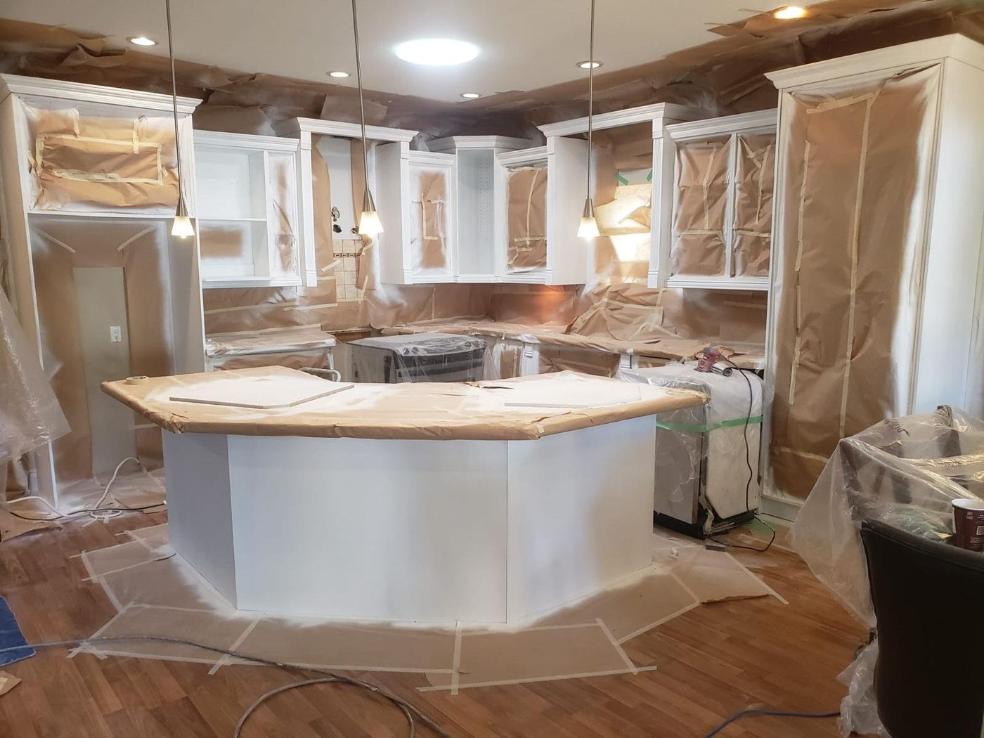 Archived kitchen cabinetry and surrounding surfaces masked for spray finishing